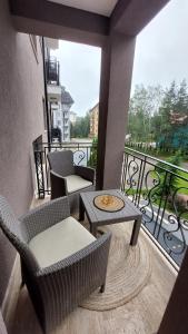 a balcony with chairs and tables and a view of a building at Apartman Vasilisa in Zlatibor