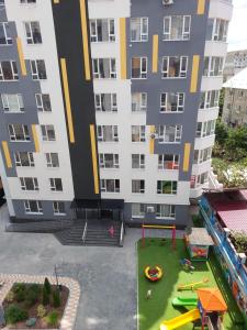 un grande condominio con parco giochi di fronte di Квартира в новострое на Ботанике a Chişinău
