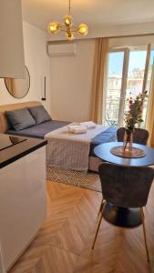 ein Schlafzimmer mit einem Bett und einem Tisch vor einer Küche in der Unterkunft Luxury apartments in DOWNTOWN of Perea in Peraia