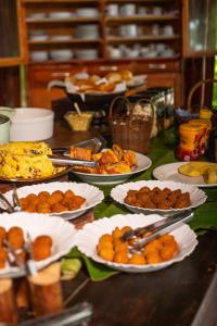 a buffet with plates of food on a table at Indaiá Eco Village in Ilhéus