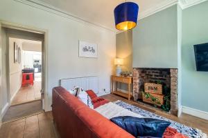 ein Wohnzimmer mit einem Sofa und einem Kamin in der Unterkunft The Bs Cycle, 4 Bedroom, 2 Bathroom, House in Harrogate Centre in Harrogate