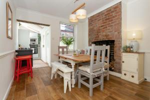 a dining room with a table and a brick wall at The Bs Cycle, 4 Bedroom, 2 Bathroom, House in Harrogate Centre in Harrogate
