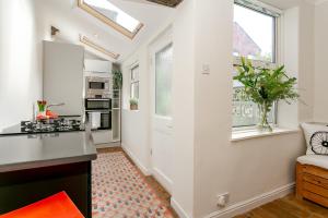 eine Küche mit weißen Wänden und Fenstern sowie einer Theke in der Unterkunft The Bs Cycle, 4 Bedroom, 2 Bathroom, House in Harrogate Centre in Harrogate + 10 Fotos