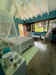 a bedroom with a bed and a couch and chairs at Guestroom los gorgones in Las Galeras