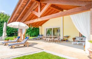 a patio with chairs and an umbrella and a table at 5 Bedroom Cozy Home In Fanzolo Di Vedelago in Fonzolo