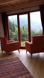 a living room with two chairs and a large window at Maçkun Suite in Rize