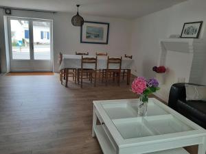 a living room with a table and a vase of flowers at Gite de la paludière in Assérac +9 photos