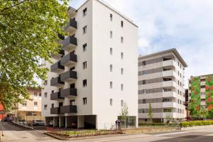 a white building with balconies on a street at Lugano Superior Suites - Free Parking in Lugano