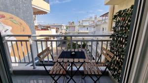 einen Balkon mit 2 Stühlen und einem Tisch auf dem Balkon in der Unterkunft Luxury apartments in DOWNTOWN of Perea in Peraia