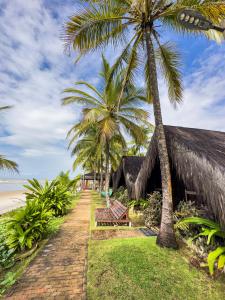 um resort com palmeiras junto à praia em Indaiá Eco Village em Ilhéus