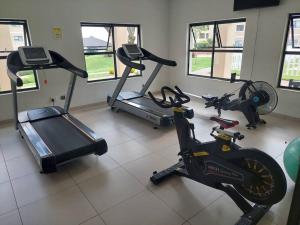 un gimnasio con 3 bicicletas estáticas y una cinta de correr en An Exquisite home away from home! en Boksburg