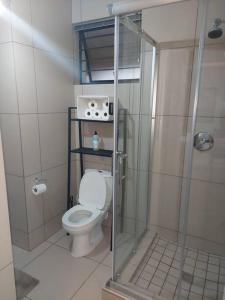 a bathroom with a toilet and a glass shower at An Exquisite home away from home! in Boksburg
