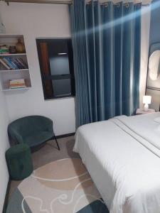 ein Schlafzimmer mit einem Bett, einem Stuhl und einem Fenster in der Unterkunft An Exquisite home away from home! in Boksburg