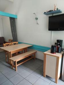 um quarto com uma mesa e dois bancos e uma televisão em Maisonnette eau turquoise em Argelès-sur-Mer