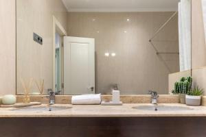 a bathroom with two sinks and a large mirror at Apartamento La Alameda de Indautxu in Bilbao