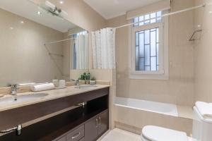 a bathroom with a sink and a toilet and a mirror at Apartamento La Alameda de Indautxu in Bilbao