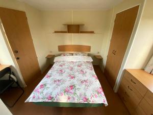 a small bedroom with a bed with a floral bedspread at Nature&Rest in Łąck
