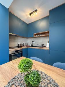 a kitchen with blue cabinets and a wooden table at Sunrise Apartment in Kotor