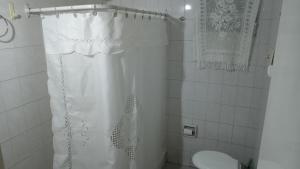 ein Badezimmer mit einem weißen Duschvorhang und einem WC in der Unterkunft Departamento Amplio con Terraza Exclusiva in Rosario