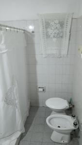 ein weißes Bad mit einem WC und einer Dusche in der Unterkunft Departamento Amplio con Terraza Exclusiva in Rosario