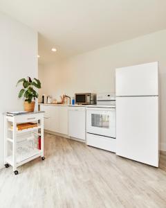 a kitchen with white appliances and a white refrigerator at The Sunset Montauk in Montauk