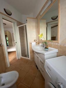 a bathroom with a sink and a toilet and a mirror at Casa dei Nonni in Ischia