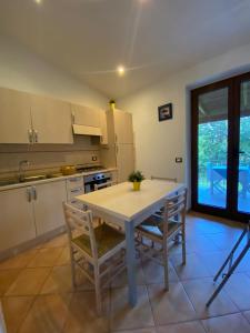eine Küche mit einem weißen Tisch und Stühlen sowie einem Fenster in der Unterkunft Casa dei Nonni in Ischia