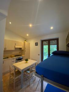 a bedroom with a bed and a table and a kitchen at Casa dei Nonni in Ischia