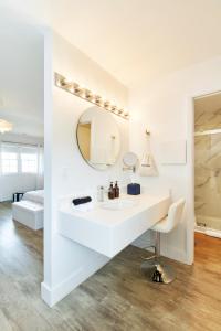 uma casa de banho branca com um lavatório e um espelho em The Sunset Montauk em Montauk