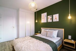 um quarto com uma parede verde e uma cama em Apartament Czeslaw em Biała Podlaska