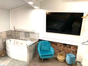 a bathroom with a tub and a blue chair at Mizzicahome SoleMare Catania in Catania +111 photos