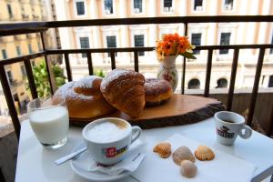 una mesa con pastas y café y dos tazas de leche en Sallù Boutique en Salerno