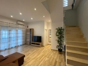un salon avec un escalier et une télévision dans l'établissement Apartamento Casa Vivian, à Mérida
