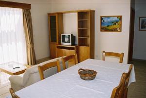 una sala da pranzo con un tavolo e una televisione di Paraiso Dourado a Porto Santo