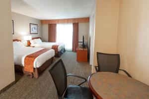 een hotelkamer met 2 bedden en een tafel en stoelen bij Anchor Inn and Suites in Campbell River