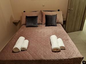 ein großes Bett mit Handtüchern und Kissen darauf in der Unterkunft Déjà Blue in Archangelos