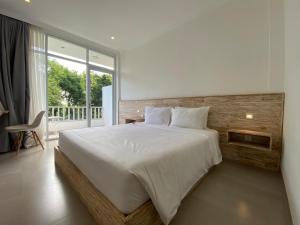 a bedroom with a large bed and a large window at Mahamustika Riverside in Canggu