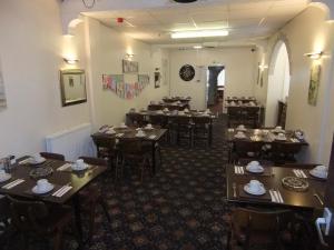 a dining room with wooden tables and chairs at Charnley Gold in Blackpool