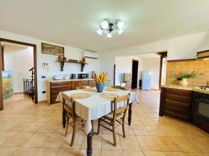 Casa Aieddu في تيراسيني: مطبخ وغرفة طعام مع طاولة وكراسي