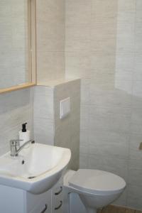 a white bathroom with a sink and a toilet at Trim Rooms and Apartments in Lovište