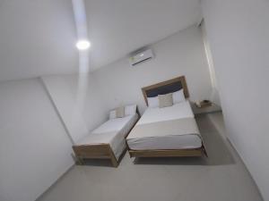 a small bedroom with two beds in a room at Hotel El Faro in Cartagena de Indias