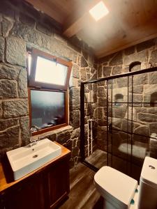 a stone bathroom with a sink and a window at AXÂRA VİLLA SUİT in Pazar