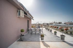 einen Balkon mit einem Tisch und Topfpflanzen darauf in der Unterkunft Central Palace Trikala in Tríkala