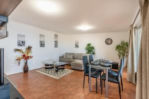 uma sala de estar com uma mesa e um sofá em Villa das Furnas em Funchal