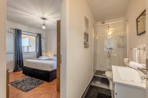 a bedroom with a bed and a bathroom with a shower at Villa das Furnas in Funchal