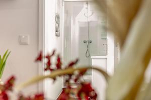 豐沙爾的住宿－Villa das Furnas，镜子里有一束红色的鲜花