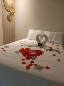 a bed with red roses and hearts on it at Pousada Vibe Guajiru in Trairi