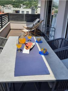 a table on a balcony with glasses of orange juice at The One in Baška Voda +58 photos
