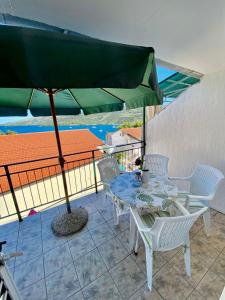 a patio with a table and chairs and an umbrella at Apartmani Ines in Marina