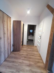 un couloir vide avec une porte et une chambre dans l'établissement Harmony Apartment, à Ostróda